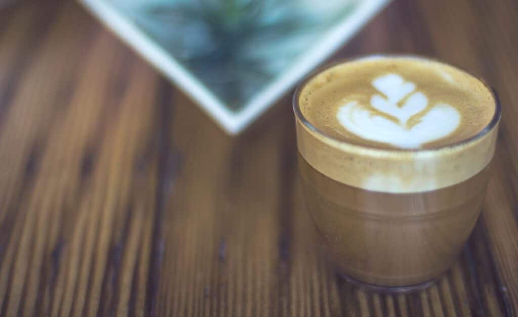 Cortado macro photography of latte in drinking glass